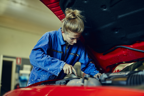 female mechanic working on a car