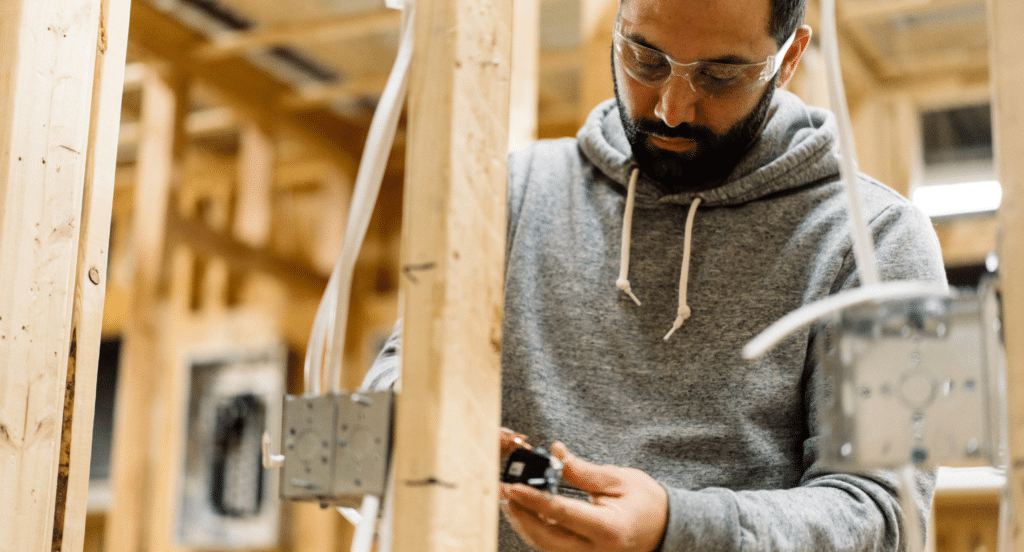 A student fixes an electrical outlet in the NEIT building lab
