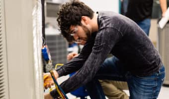 Student making HVAC repairs