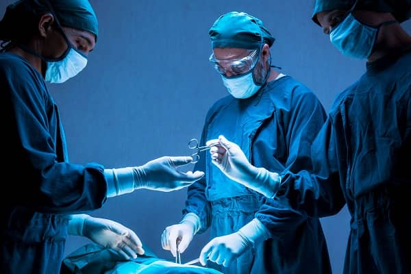 A team of surgical techs assisting a doctor in surgery 