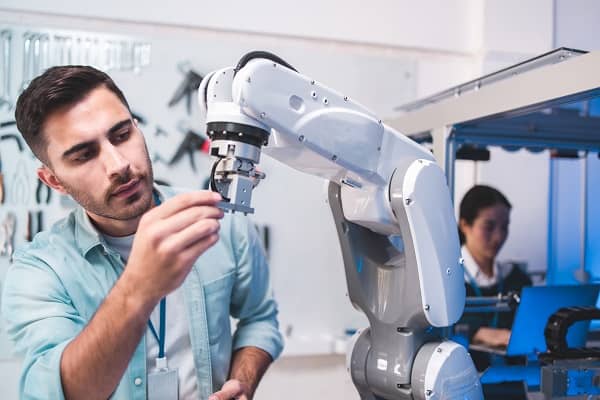 Robotics engineers studying a robotic arm