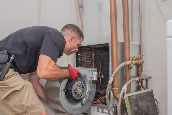 Hvac repair technician removing a blower motor from air handler