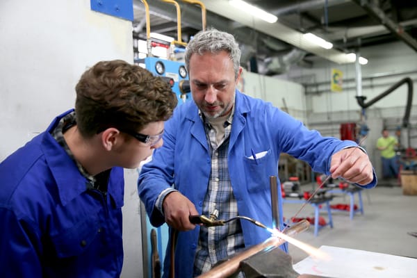 Master plumber teaching an apprentice