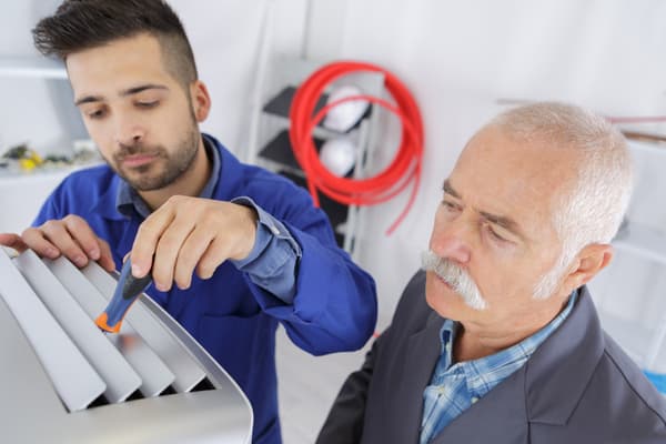 two ac technicians repairing an industrial AC compressor