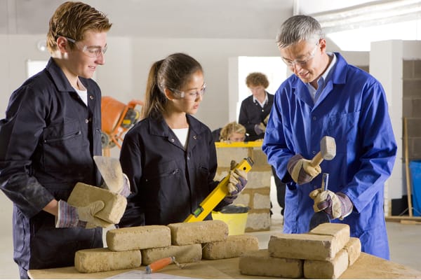Teacher teaching students bricklaying in vocational school