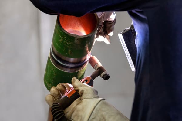 The welder is welding to pipe